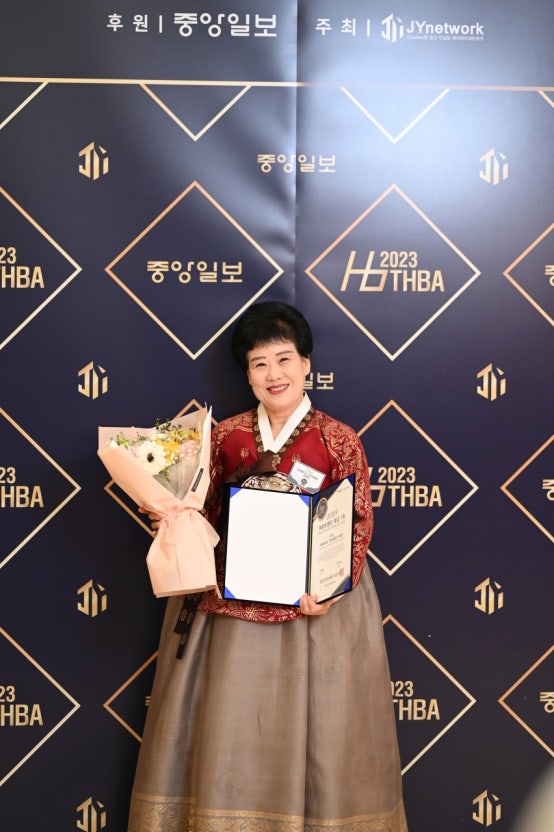 2023 히트브랜드 대상 포토월 앞에서 꽃다발과 상장을 든 류제월 대표